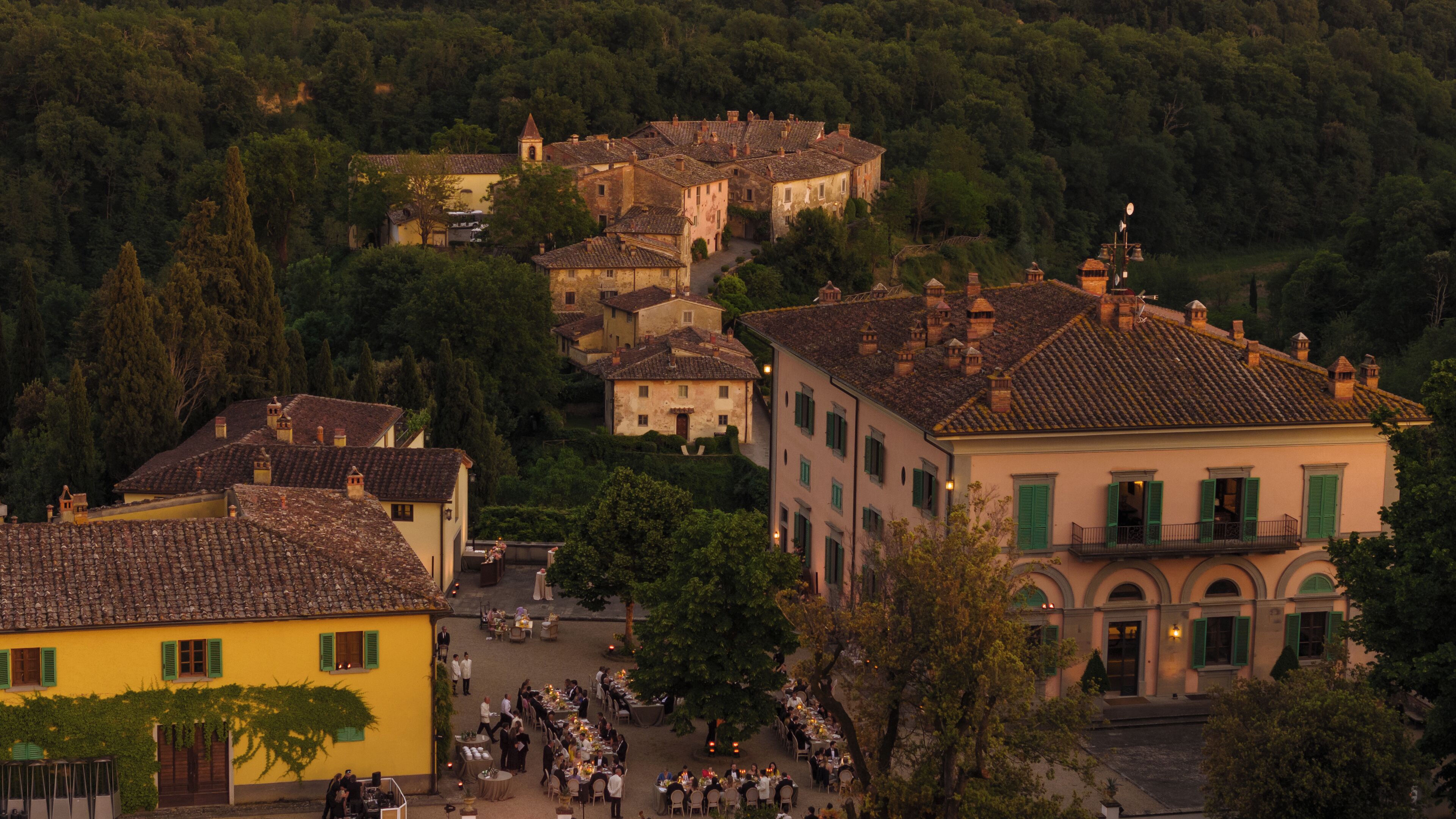 Un village historique à l’architecture traditionnelle, avec des bâtiments aux toits de tuiles et une place centrale dotée de terrasses.