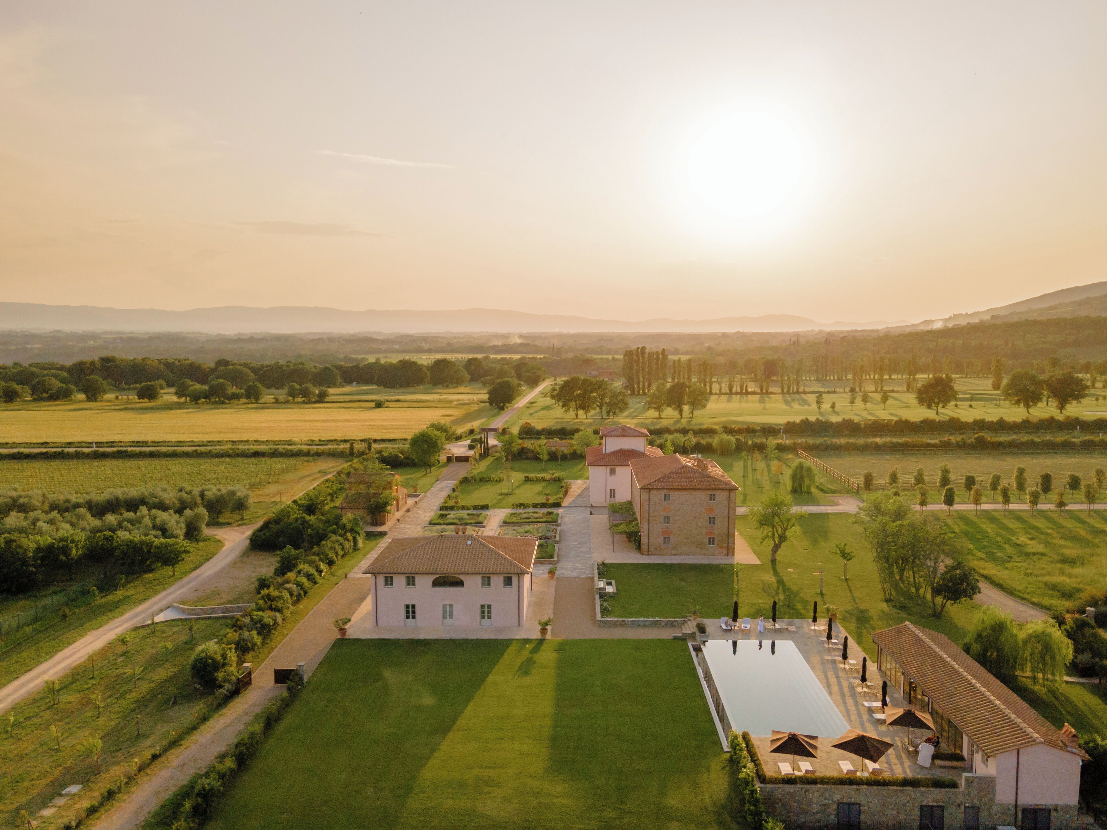 A large estate with multiple buildings, expansive lawns, and a swimming pool.