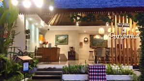 A hotel entrance with a reception desk, a staircase leading inside, and a sign reading "Villa Purcartha". - Villa Puriartha Ubud (Ubud)