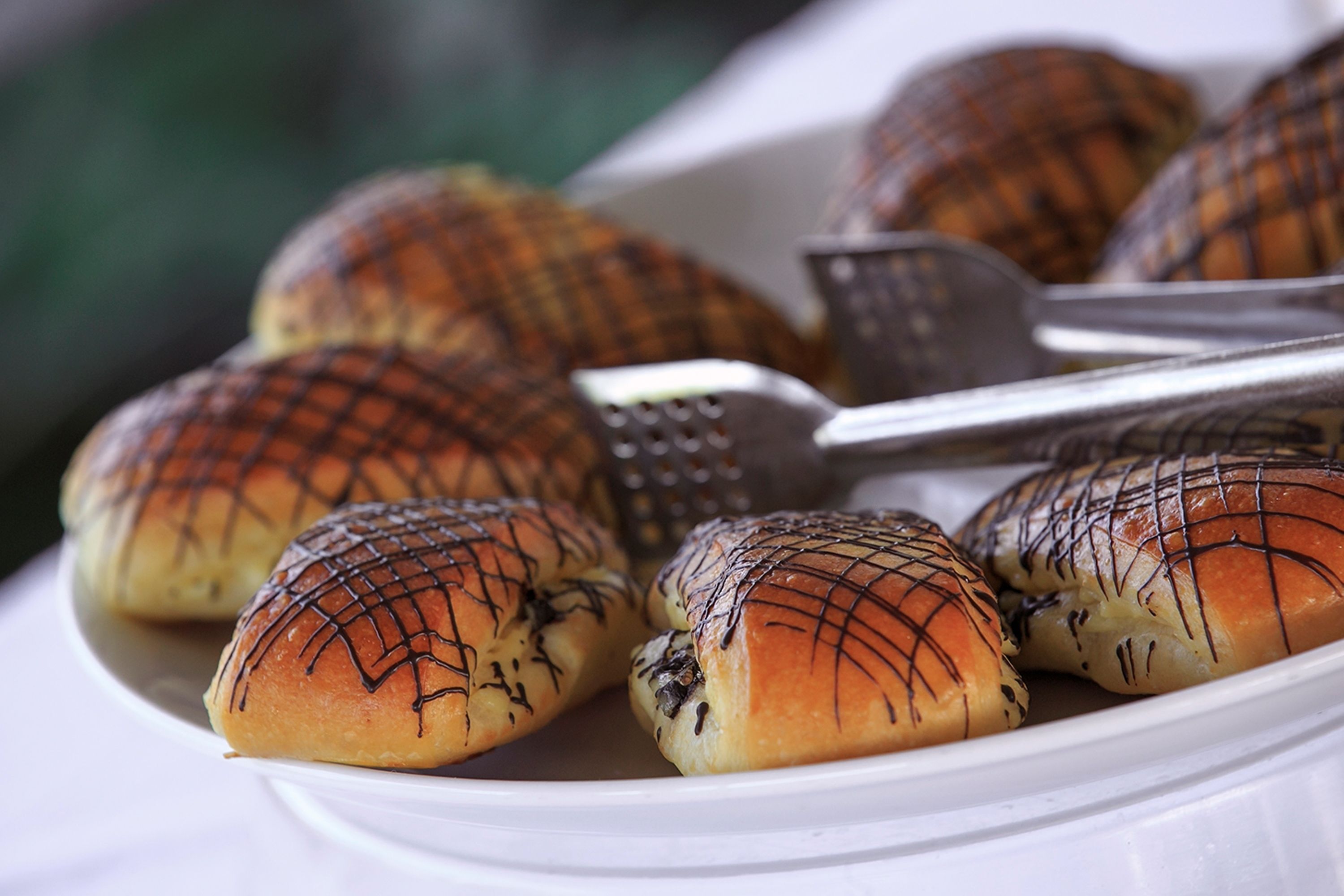 A plate of baked goods with chocolate drizzle.