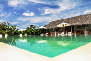Una piscina al aire libre, sillones reclinables de piscina