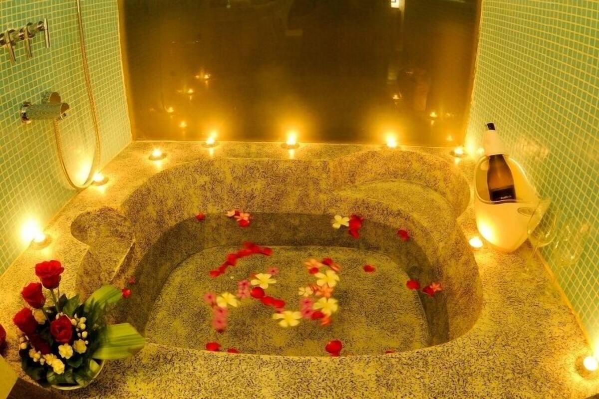Un jacuzzi con pétalos de rosa y velas.