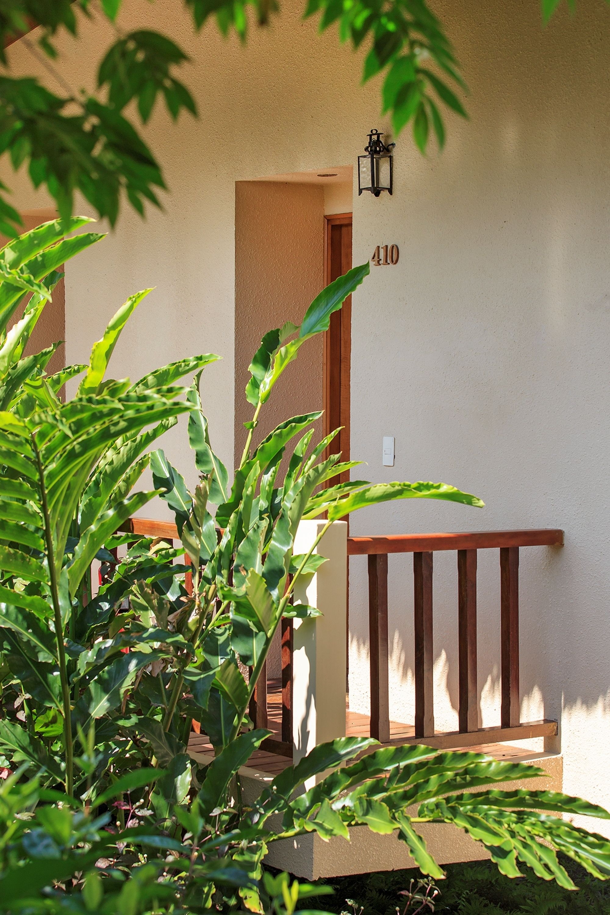 A building entrance with a wooden railing, a door, and a number '410' on the wall.
