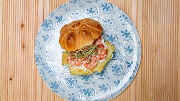 Un sandwich servi sur une assiette ornée d’un motif floral bleu.