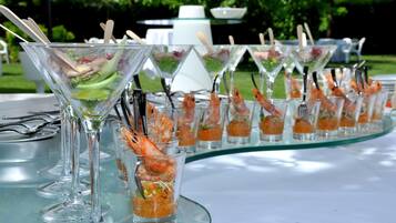 A table with a variety of drinks, including martini glasses and shot glasses, arranged in a row.
