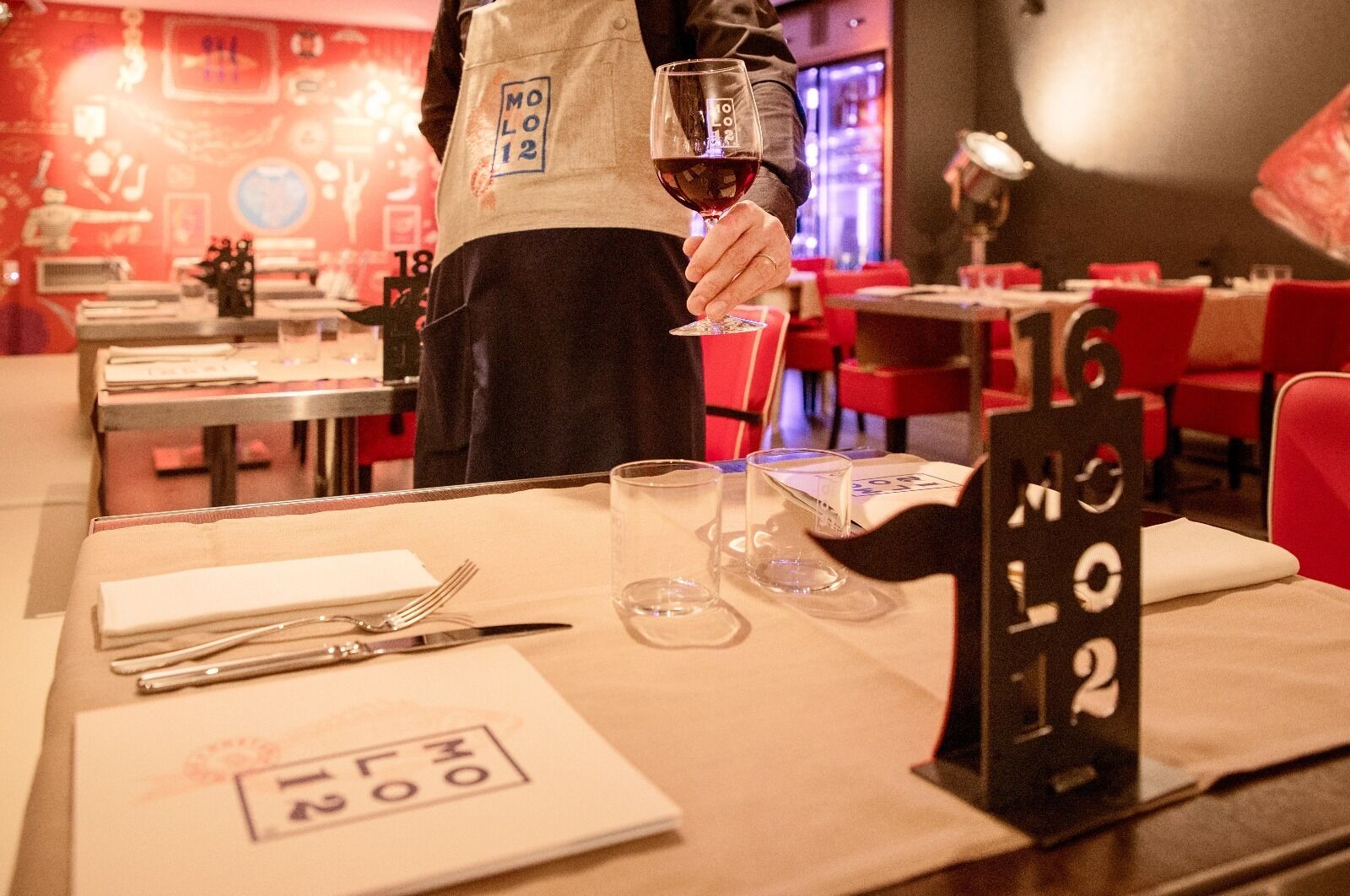 A restaurant setting with a table set for two, including cutlery and glasses.