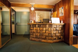 A reception area with a stone wall, a clock, and a framed picture on the wall.