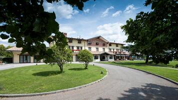 Ein Hotel mit Innenhof, überdachter Außenbereich und gepflegtem Rasen.