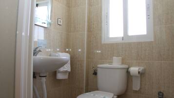 Un bagno piccolo con il water, il lavandino e un bidet.