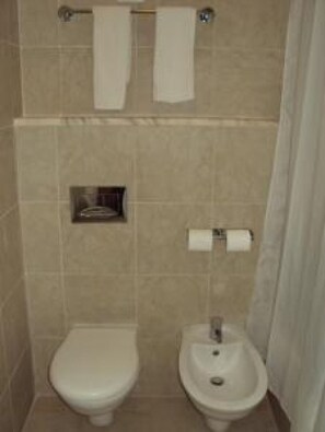 A bathroom with a toilet, bidet, and towel rack. - Grand View Resort (PETRA)