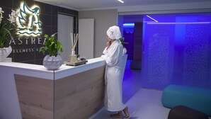 A reception area with a modern design, including a reception desk, a logo, and a blue-lit wall. - L'Araba Fenice (Altavilla Silentina)
