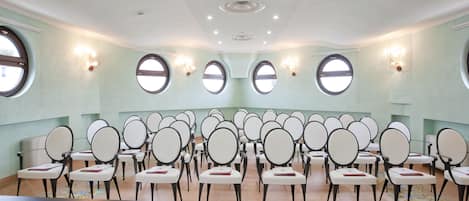 A conference room with a long table and multiple chairs arranged in rows.