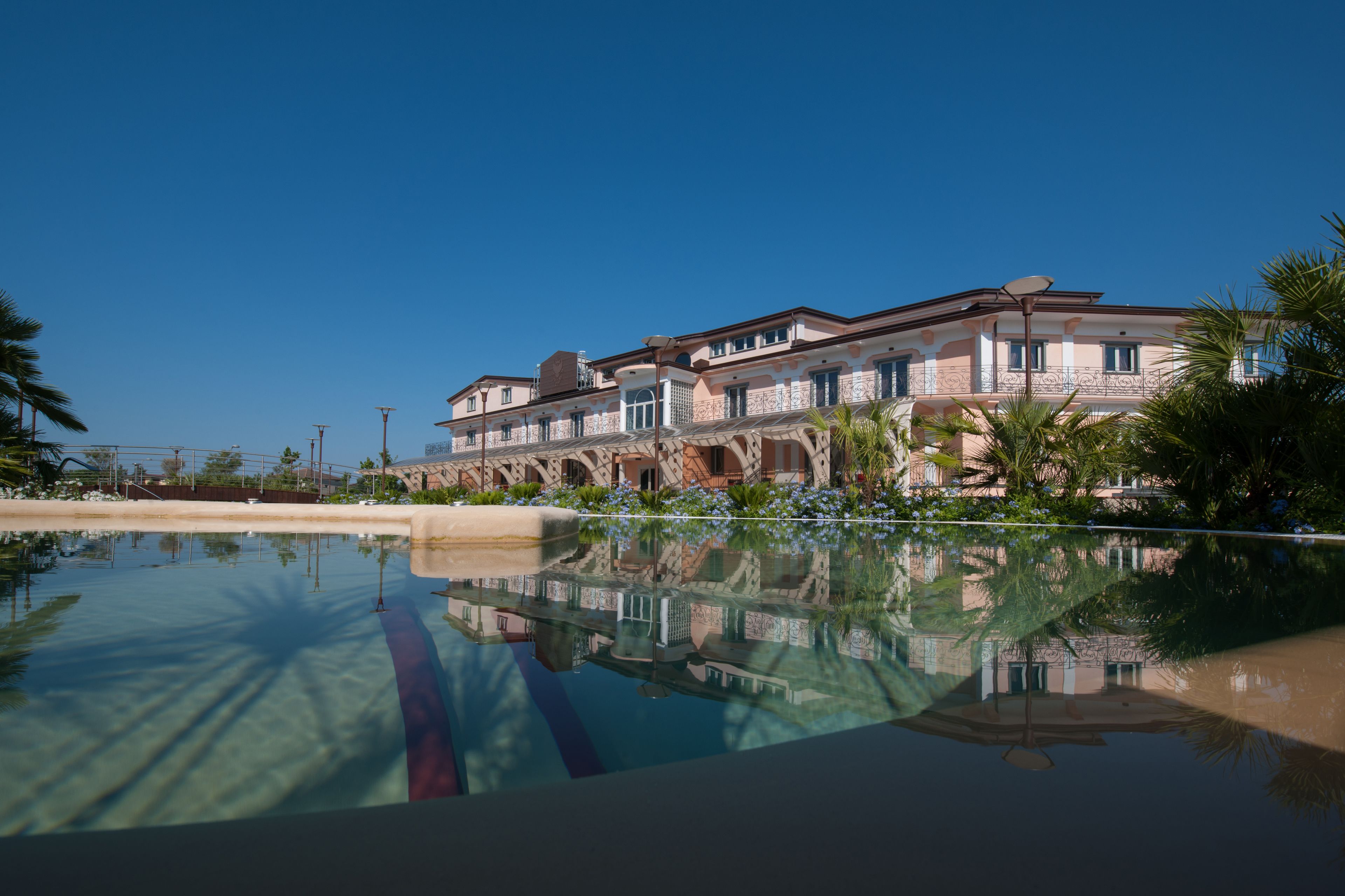 A large, multi-story building with a reflective pool in the foreground.