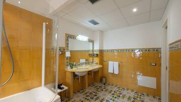 Un baño con bañera, dos lavamanos, un espejo y ducha.