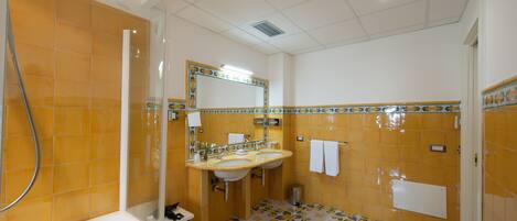 Un baño con bañera, dos lavamanos, un espejo y ducha.