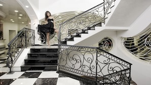 A grand staircase with ornate black metal railings and a black and white checkered floor. - L'Araba Fenice (Altavilla Silentina)