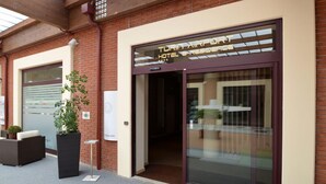 Entrada de un hotel con puerta de vidrio y un letrero que dice 'Turin Airport Hotel Residence'.