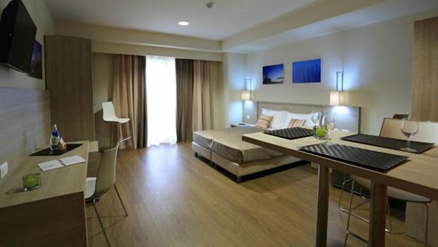 Una habitación de hotel moderna con cama, escritorio y zona de estar.