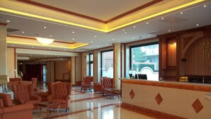 A spacious lobby with a reception desk, several armchairs, and a polished floor. - Palace Hotel Legnano (Legnano)