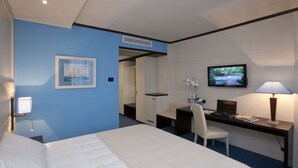 A hotel room with a bed, a desk with a computer, a TV, and a chair. - Palace Hotel Legnano (Legnano)