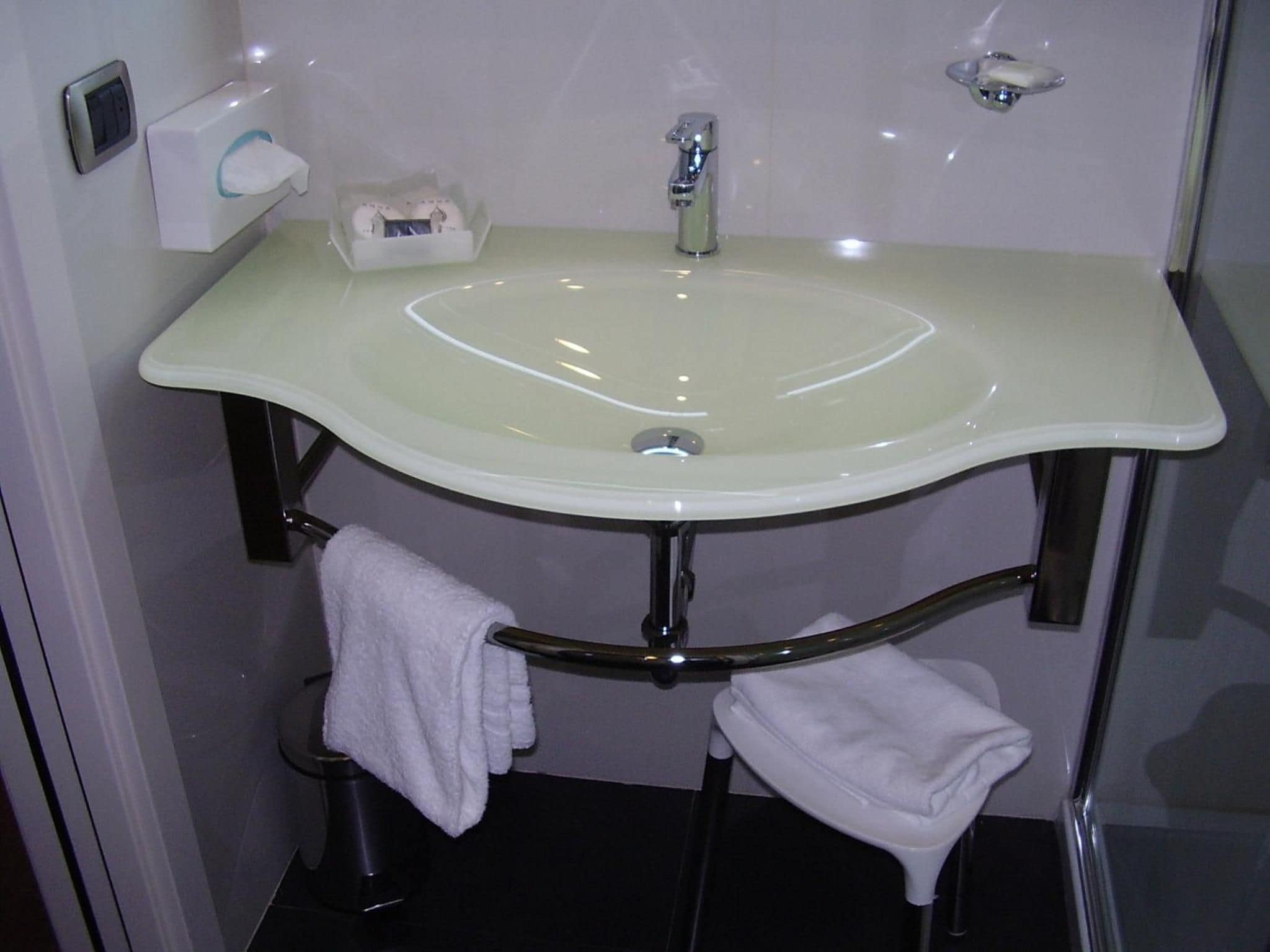 A bathroom with a white sink, a towel rack, and a toilet.