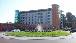 A hotel with a central fountain, multiple floors, and a modern glass facade. - Palace Hotel Legnano (Legnano)