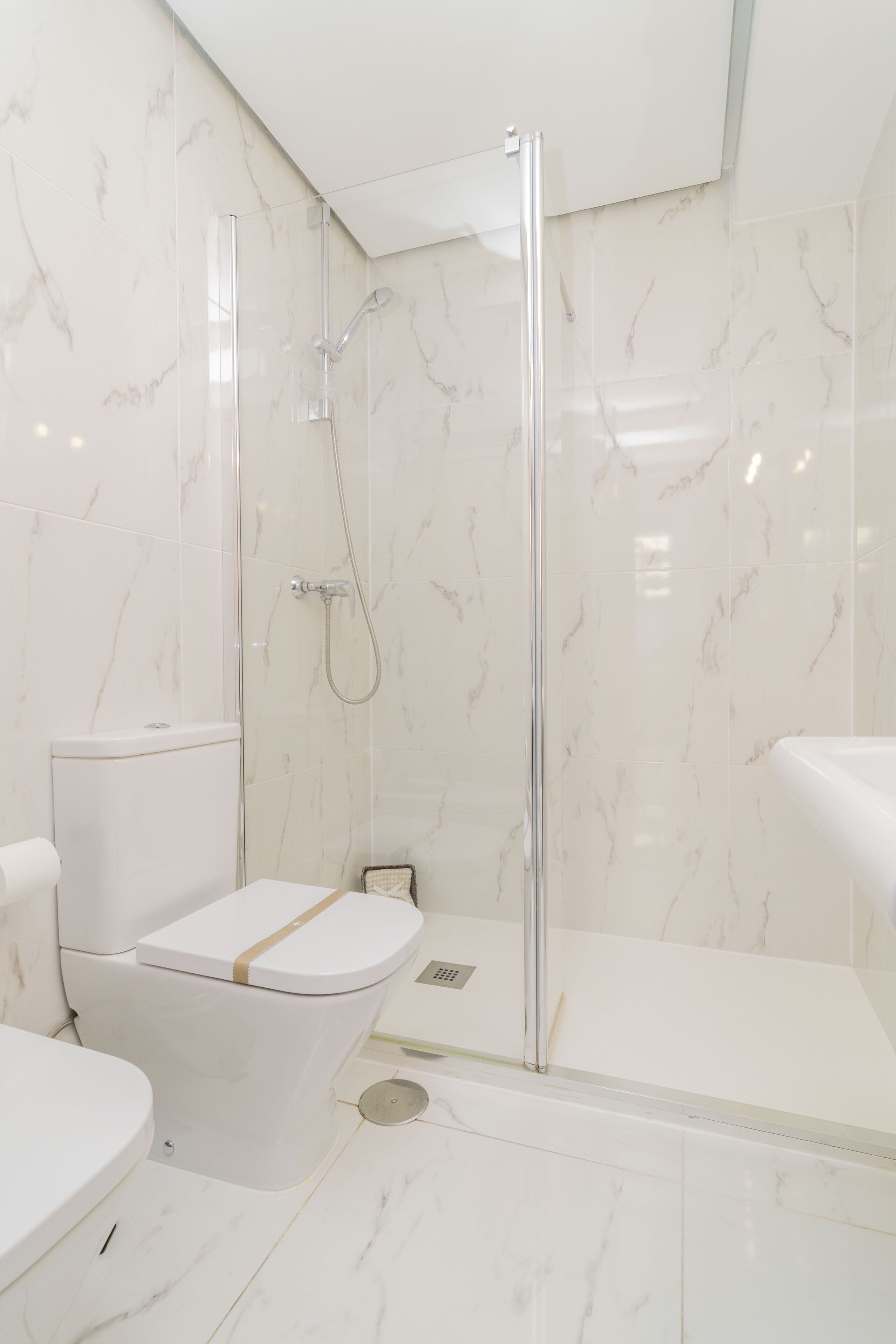 A modern bathroom with a glass-enclosed shower, a toilet, and a bathtub.
