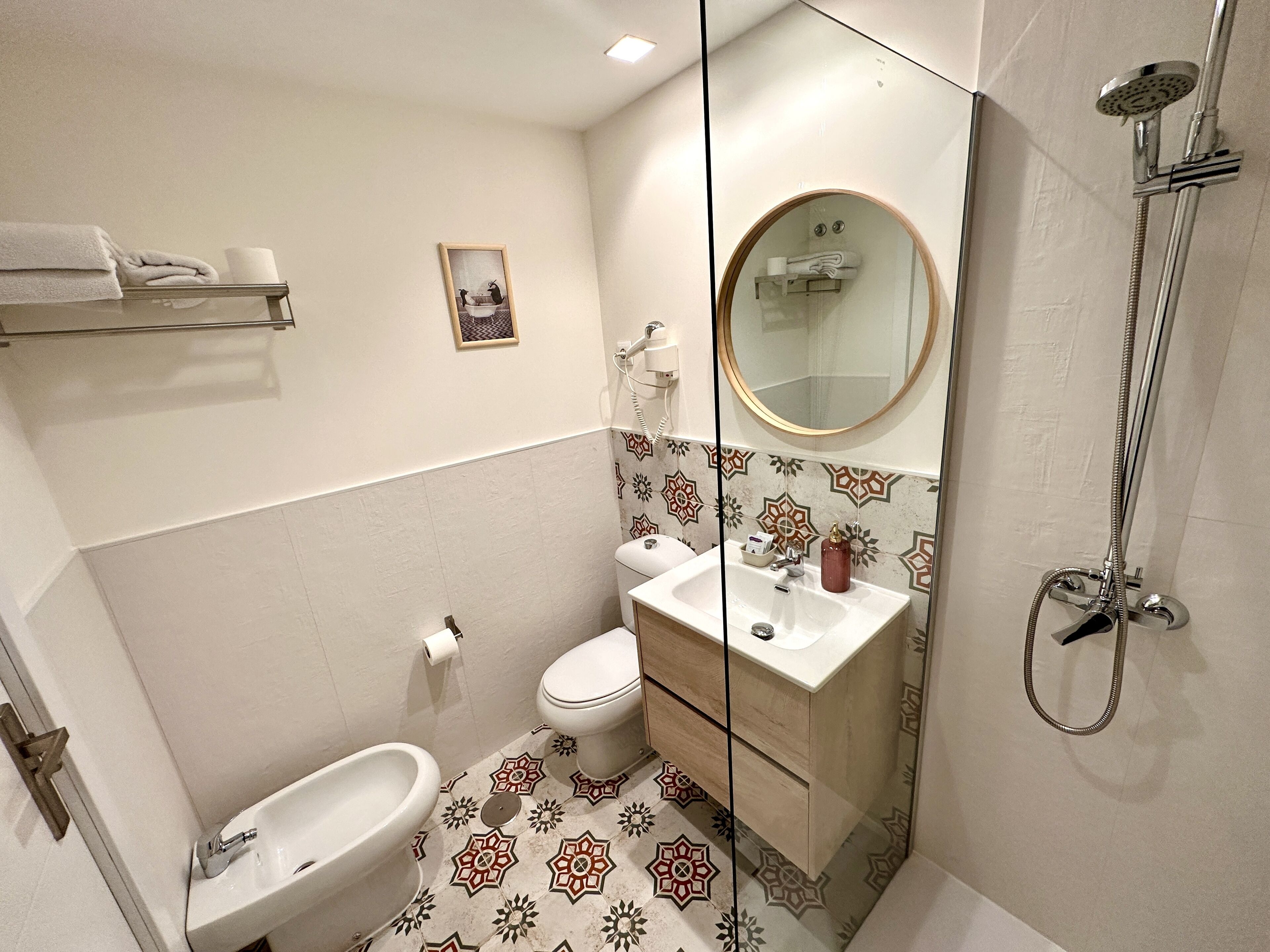 A compact bathroom with a toilet, bidet, and a shower.