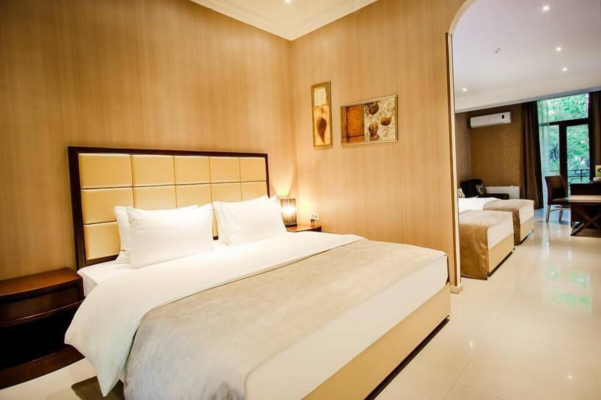 Una habitación de hotel con una cama grande, una mesita de noche, un escritorio y una silla.