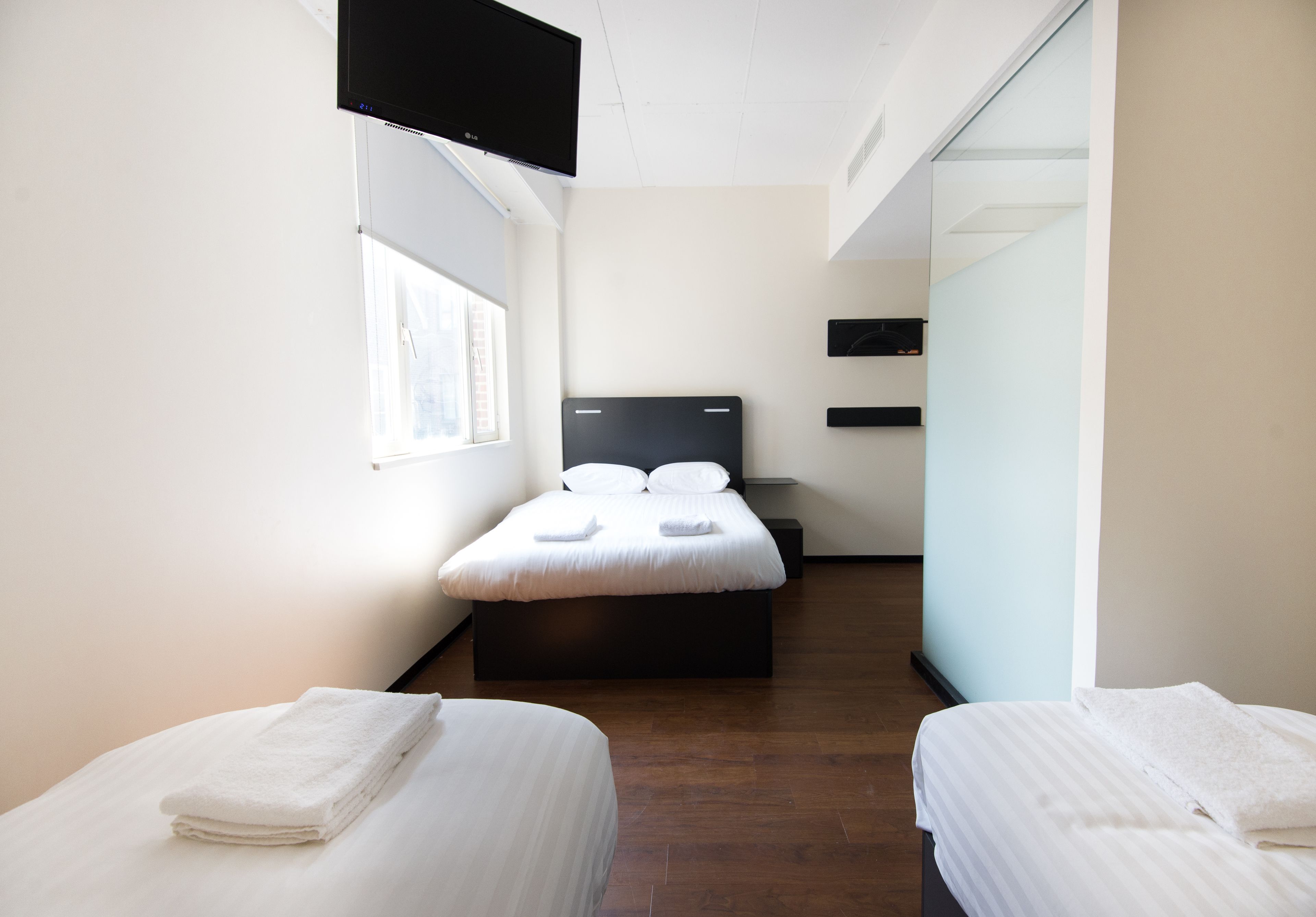 Une chambre d’hôtel avec un lit, une télévision et une fenêtre.