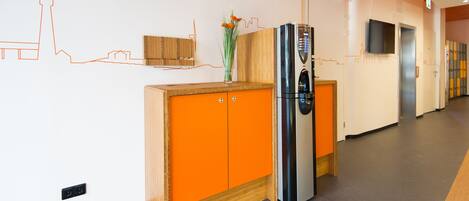 Una cocina moderna con un armario de madera, un refrigerador de acero inoxidable y un florero con flores en la encimera.