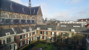 Un edificio histórico con una torre destacada y ventanas amplias.