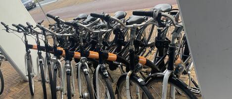 Uma fileira de bicicletas estacionadas em um ponto de parada, provavelmente para um serviço de compartilhamento de bicicletas.