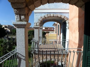 A balcony with stone railings and an archway leading to a building. - Sa Tanchitta (Valledoria)
