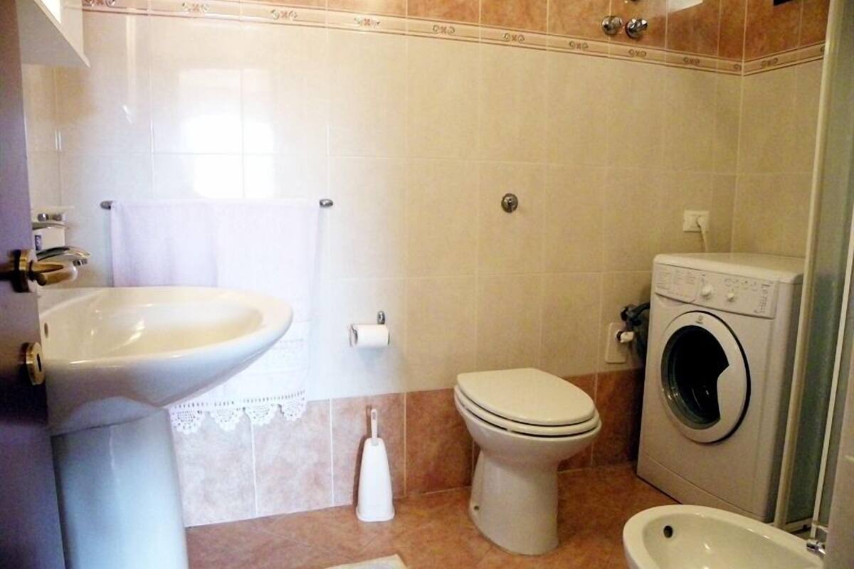 Un baño con lavamanos, inodoro, lavadora y bidé.