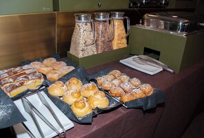 Una mesa de buffet con diversos pasteles y una estación de café.