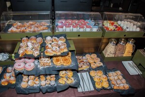 Un buffet con diversi dolci e pasticcini esposti in contenitori trasparenti.