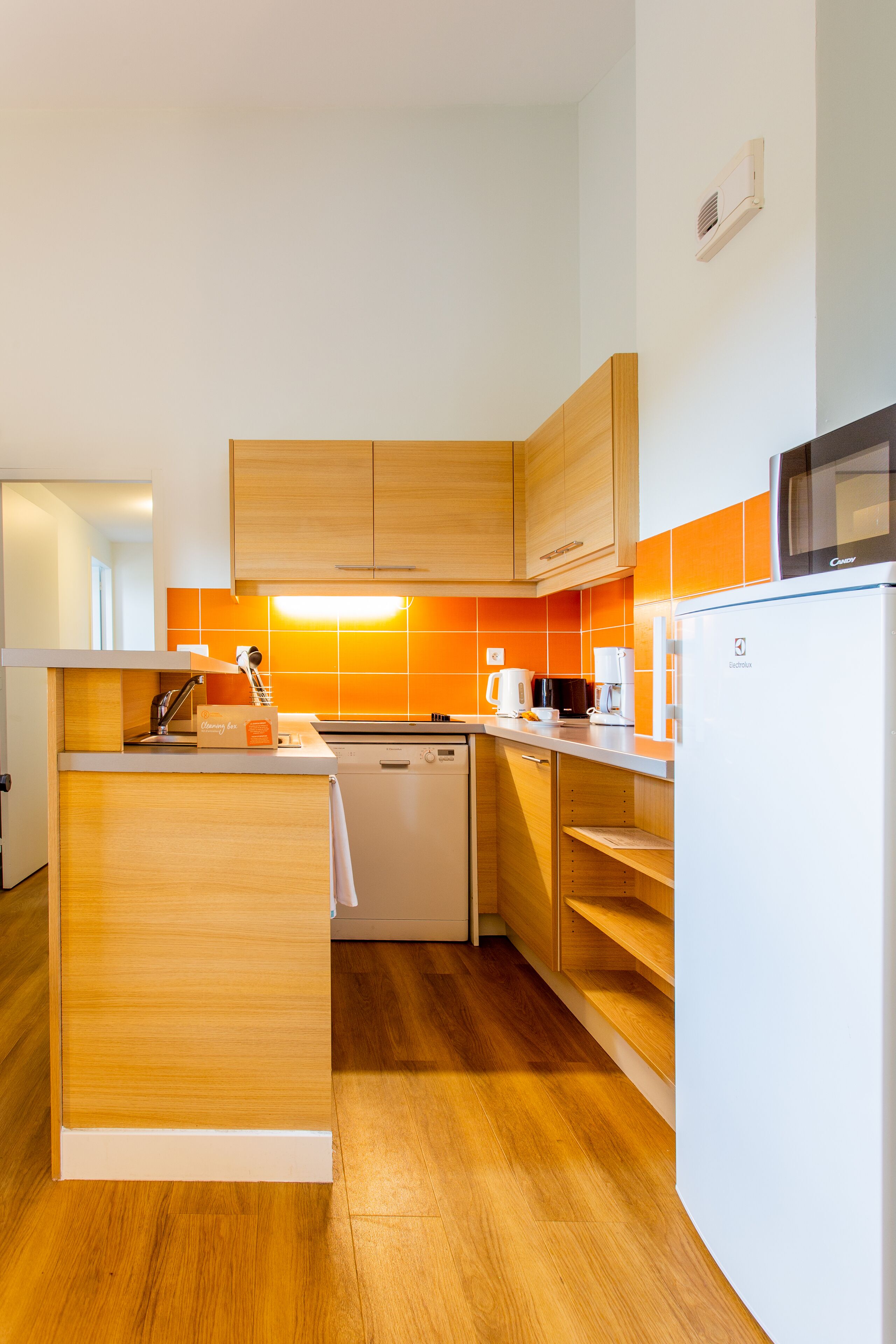 Una cocina moderna con armarios de madera, lavavajillas integrado y microondas.