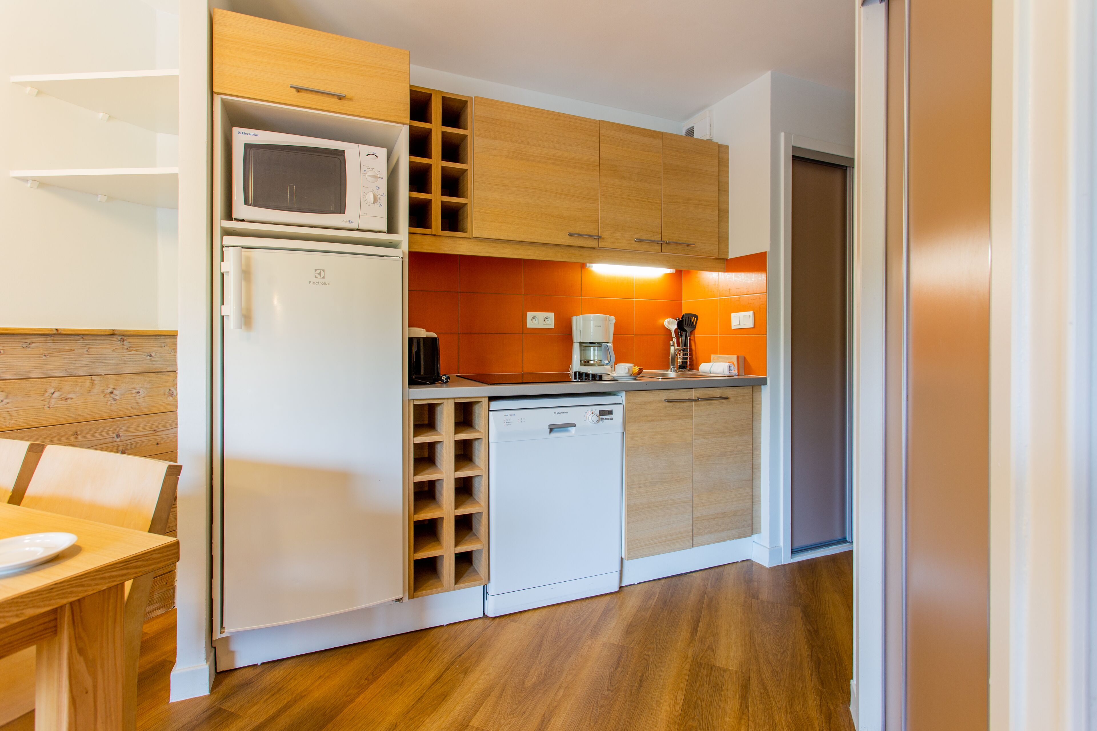 A compact kitchen with a microwave, refrigerator, and dishwasher.