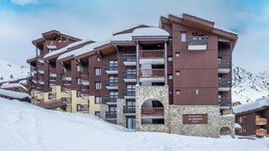 A multi-story hotel with balconies and a stone entrance. - Residence Pierre & Vacances Les Gemeaux (La Plagne-Tarentaise)