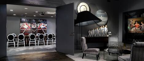 Un interior moderno con comedor, sala de estar con una lámpara grande y televisor.