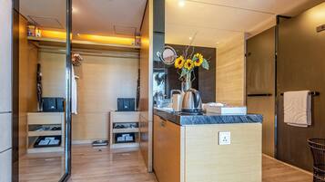 A modern bathroom with a vanity, mirror, and a vase of sunflowers.