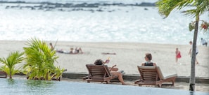 Una piscina al aire libre, sombrillas, sillones reclinables de piscina