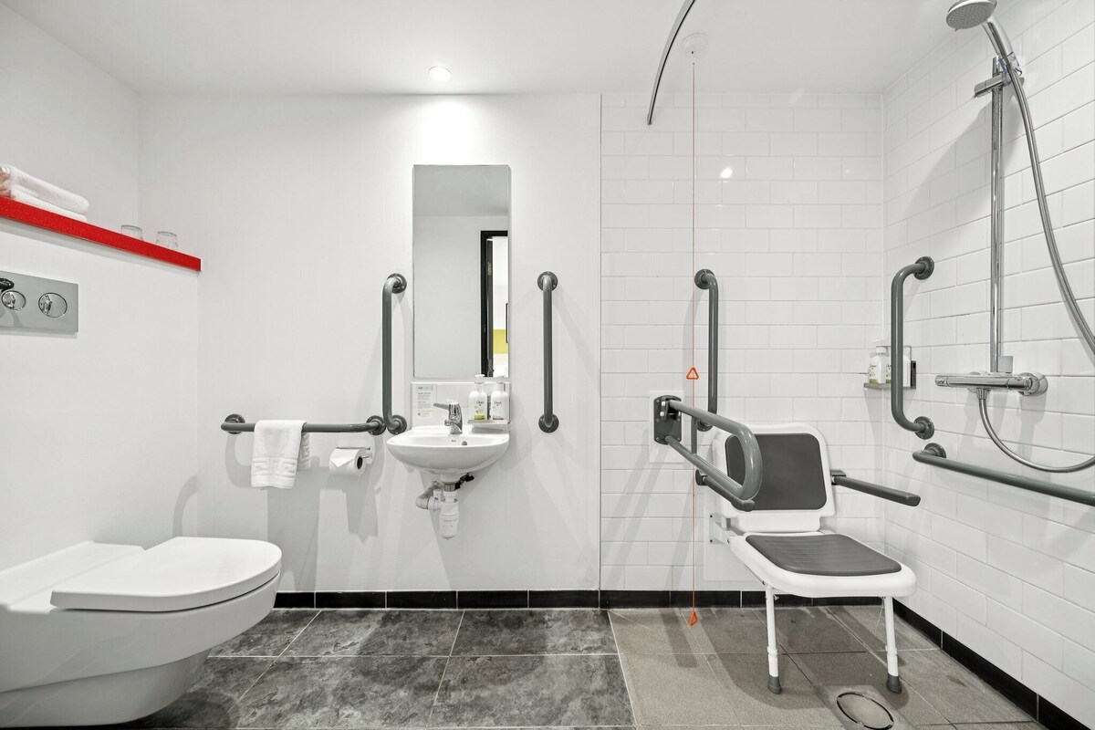 Un baño moderno con inodoro, lavabo y ducha.