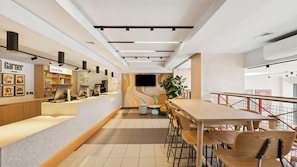 Un interior moderno con mostrador, zona de estar y una escalera.