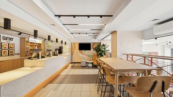 A modern interior with a counter, seating area, and a staircase.