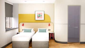 A modern hotel room with two beds, a window, a door, and a framed picture on the wall.