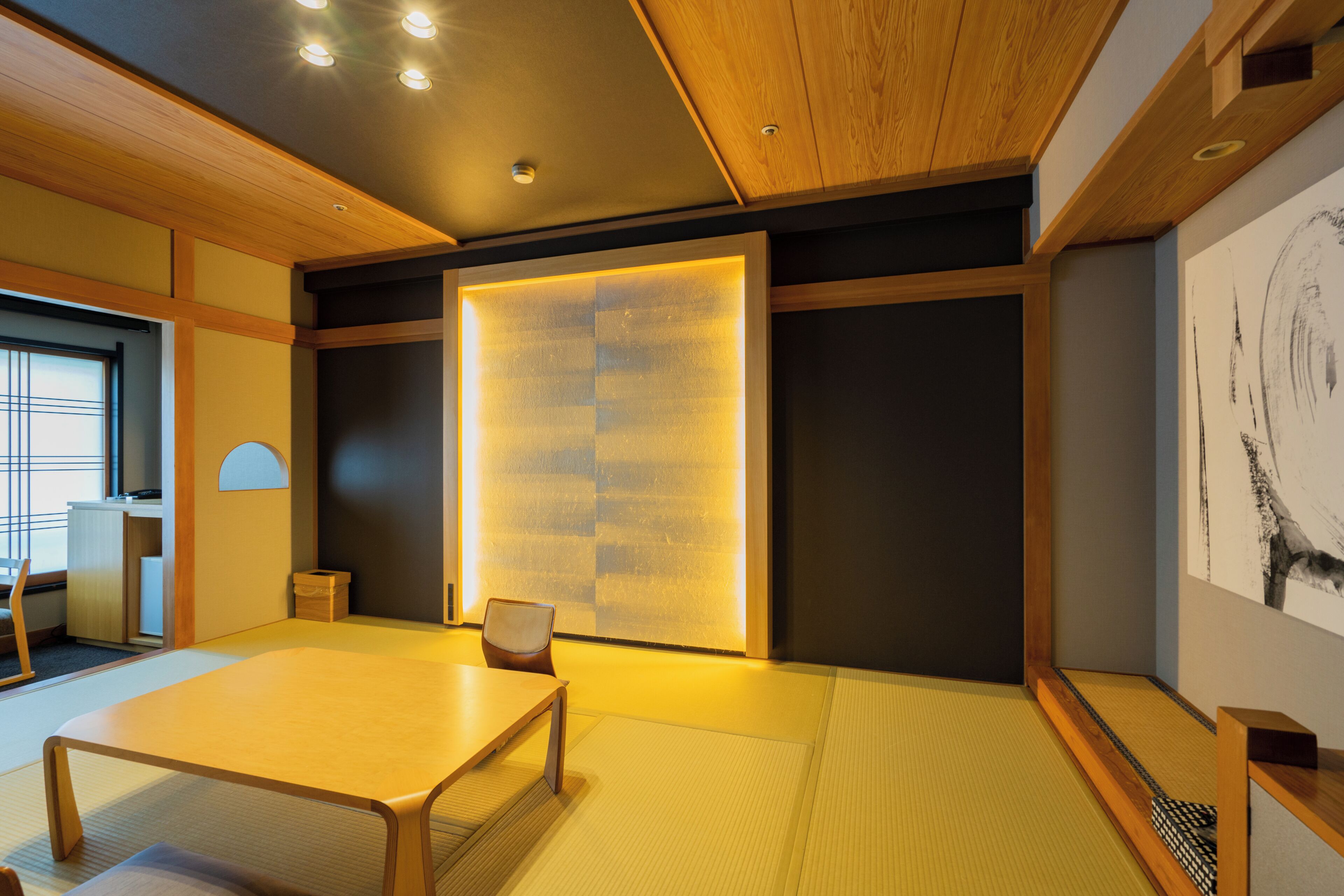 A traditional Japanese room with tatami flooring, a low wooden table, and a sliding door with a light panel.