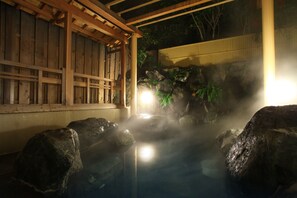 A traditional Japanese onsen with wooden structures and rocks. - Ito Kowakien (Ito)