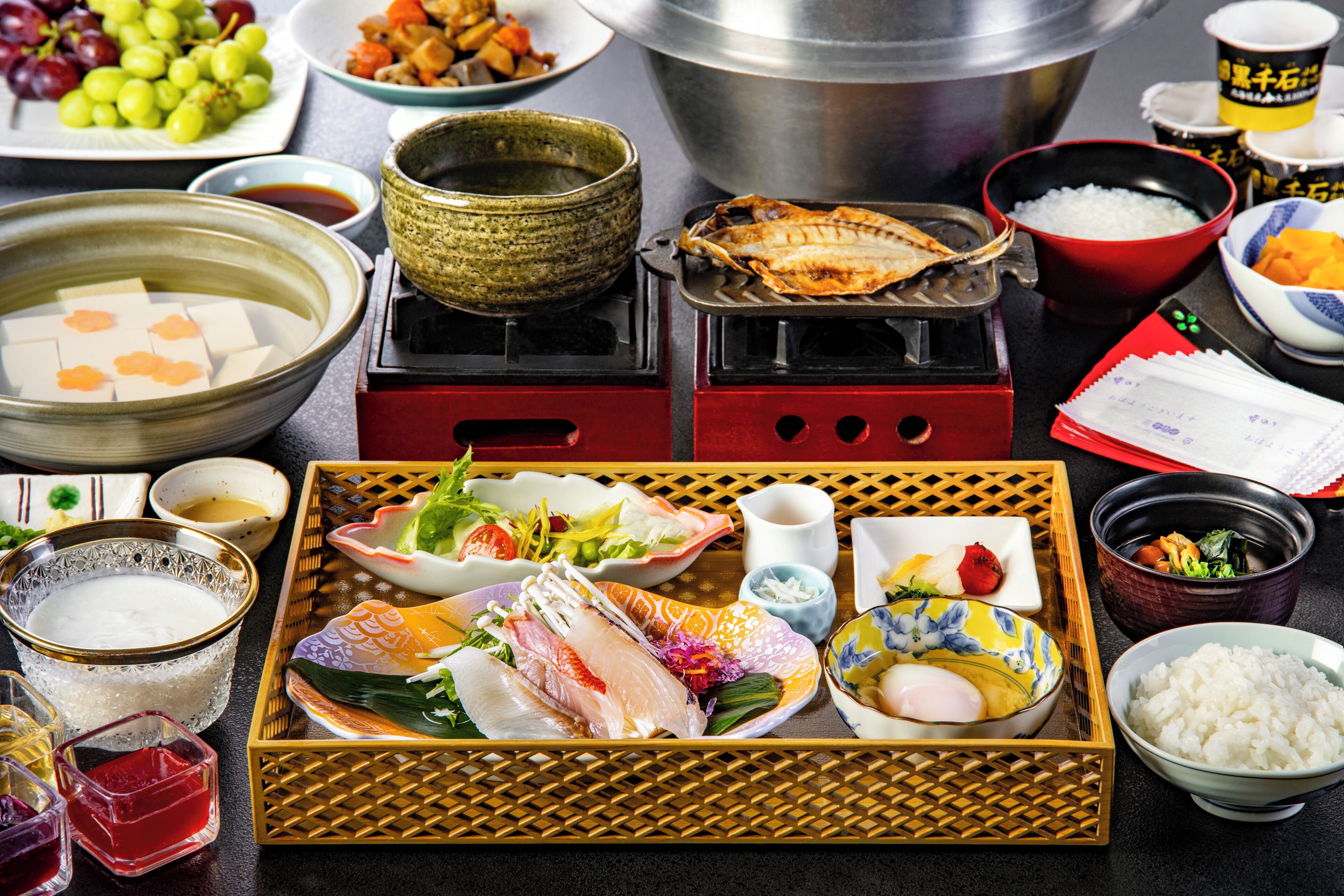 A variety of Japanese dishes, including sushi and rice, arranged on a tray.